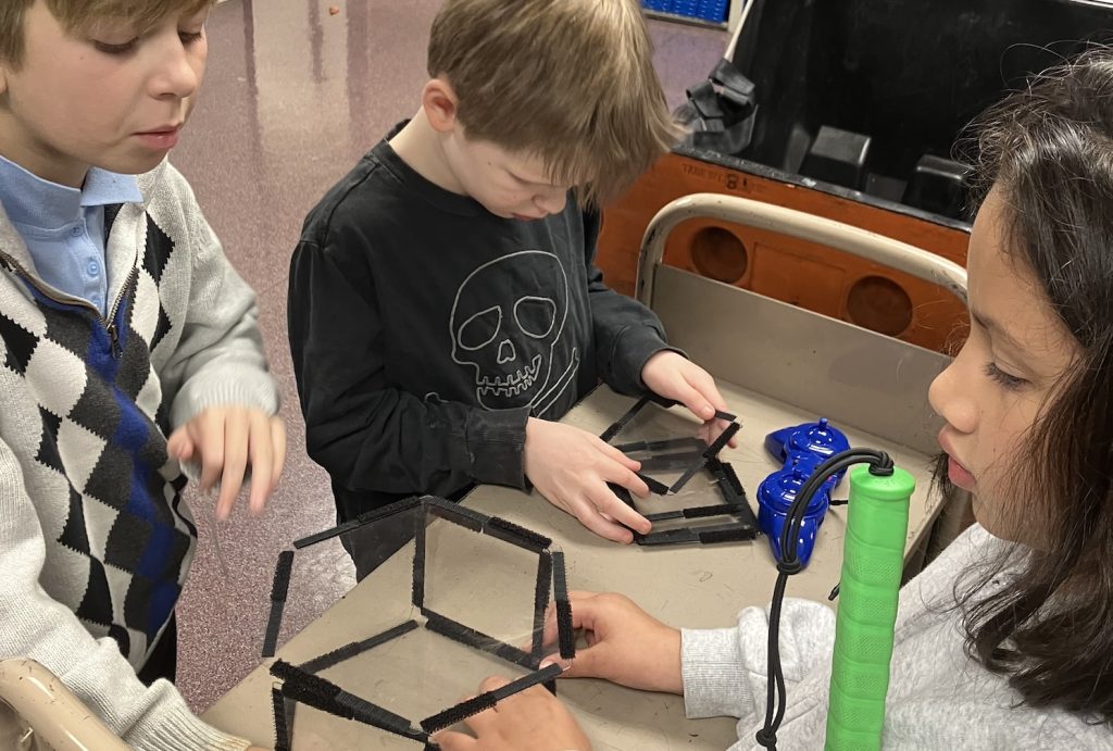 three kids working with the Geometro Kit