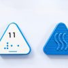 Front and back of blue triangular Reach & Match Number tile showing the number 11 in Nemeth braille and print. The back side is textured.