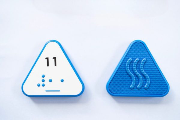 Front and back of blue triangular Reach & Match Number tile showing the number 11 in Nemeth braille and print. The back side is textured.