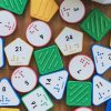 A variety of Nemeth Reach and Match number tiles spread out on a wooden surface.