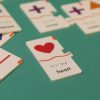 A close up of one heart puzzle piece on a teal background. Other pieces are out of focus in the background.