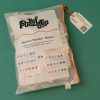 The Memory Puzzles: Shapes bag laid on a teal background. The sticker on the bag contains the Puzzled Company's logo as well as small graphics depicting the puzzle pieces in the kit.