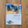 The Reach and Match Light print guidebook laid on a wooden floor.