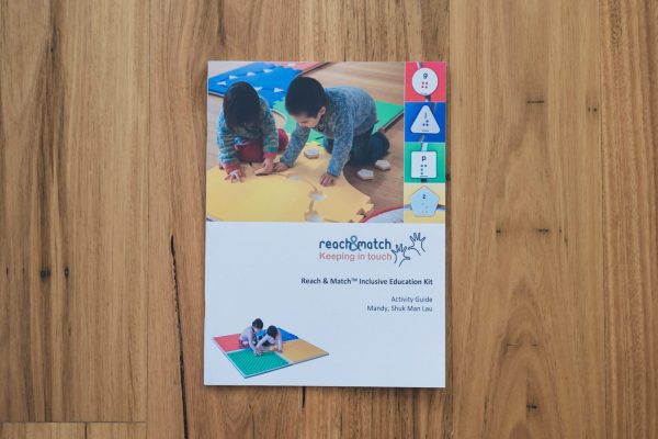 The Reach and Match Light print guidebook laid on a wooden floor.