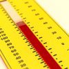 A close up of the yellow Tactile Demonstration Thermometer on a white background. In the center of the thermometer is a red velvet "mercury column" that can be adjusted with a clear easy-grip indicator. The edges of the photo are blurred with a crisp focus in the center of the thermometer.