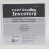 A three-ring Basic Reading Inventory binder labeled "Large Print" standing on a white background. The black and gray cover says, "Basic Reading Inventory - Student Word Lists, Passages, and Early Literacy Assessments" and list the authors.