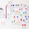 The 52 pairs of Memory Puzzles: Shapes (Spanish) spread out on a white background next to the pouch they come in.