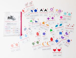 The 52 pairs of Memory Puzzles: Shapes (Spanish) spread out on a white background next to the pouch they come in.