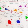 A variety of spanish Memory Puzzles: Shapes pieces scattered on a white surface. Some of the pieces are paired.