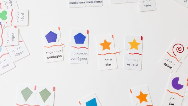 Two pairs of Memory Puzzles: Shapes with one English piece and one Spanish piece (pentagons and stars).
