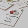 A close-up of the apple puzzle piece that says "apple" in print and braille. The piece has a wavy tactile indicator as well as a small tactile square in the top right corner.