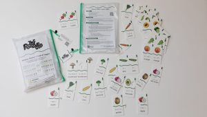 All the pieces from the Memory Puzzles: Fruits & Veggies kit spread out on a white background. The kit comes in two pouches with green zippers.