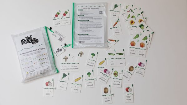 All the pieces from the Memory Puzzles: Fruits & Veggies kit spread out on a white background. The kit comes in two pouches with green zippers.