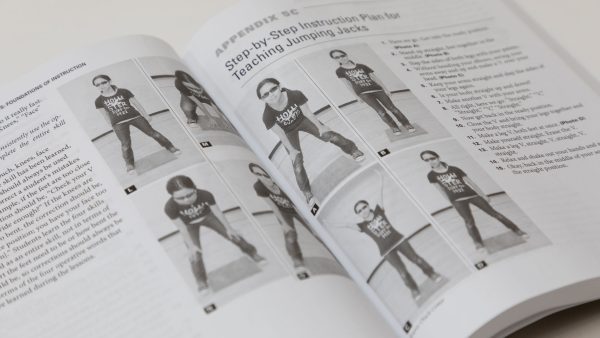 Two opened pages of PE and Sports with photos of a girl demonstrating how to do adapted jumping jacks.
