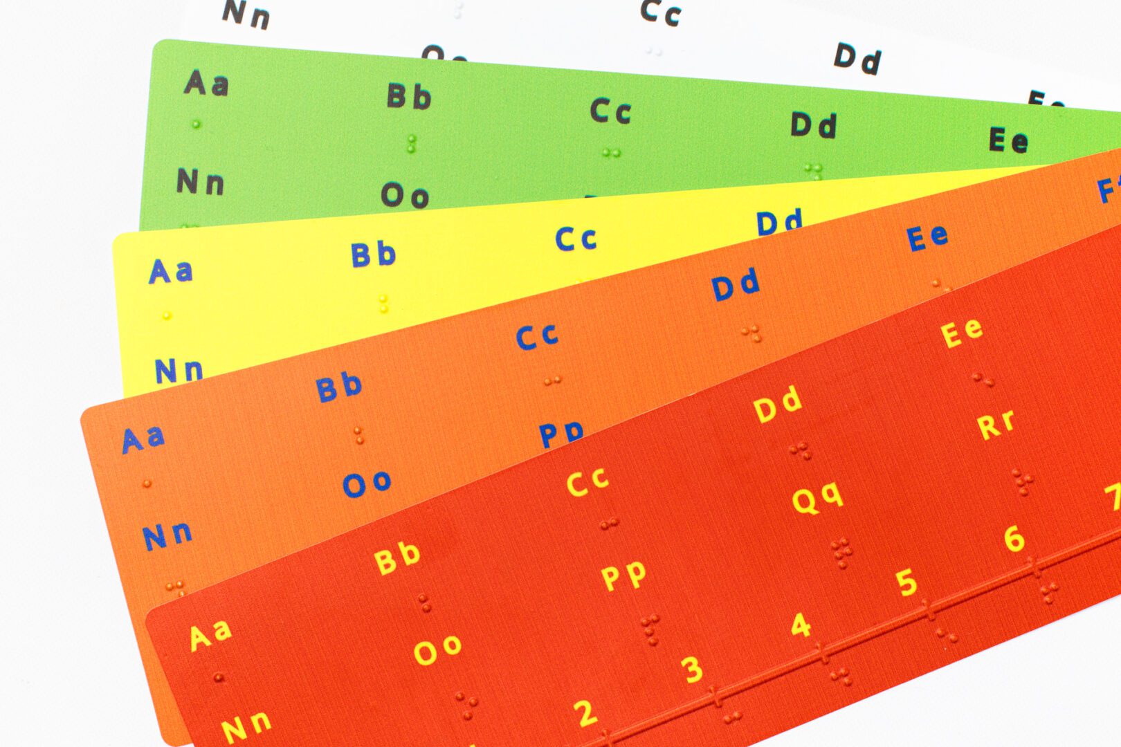 Alphabet-Number-Line-4Z9A3683-web A set of five Alphabet Number Lines fanned out in a stack. Each number line features letters and numbers in large print and braille.