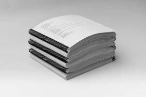 A stack of all the volumes included in the BOP 2nd Grade Unit 1 Braille Teacher's Kit.