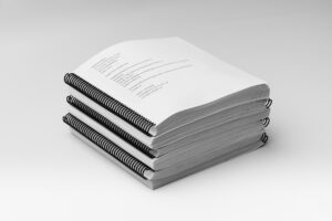 A stack of all the volumes included in the BOP 2nd Grade Unit 3 Braille Teacher's Kit.