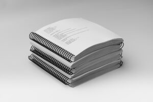 A stack of all the volumes included in the BOP 2nd Grade Unit 5 Braille Teacher's Kit.