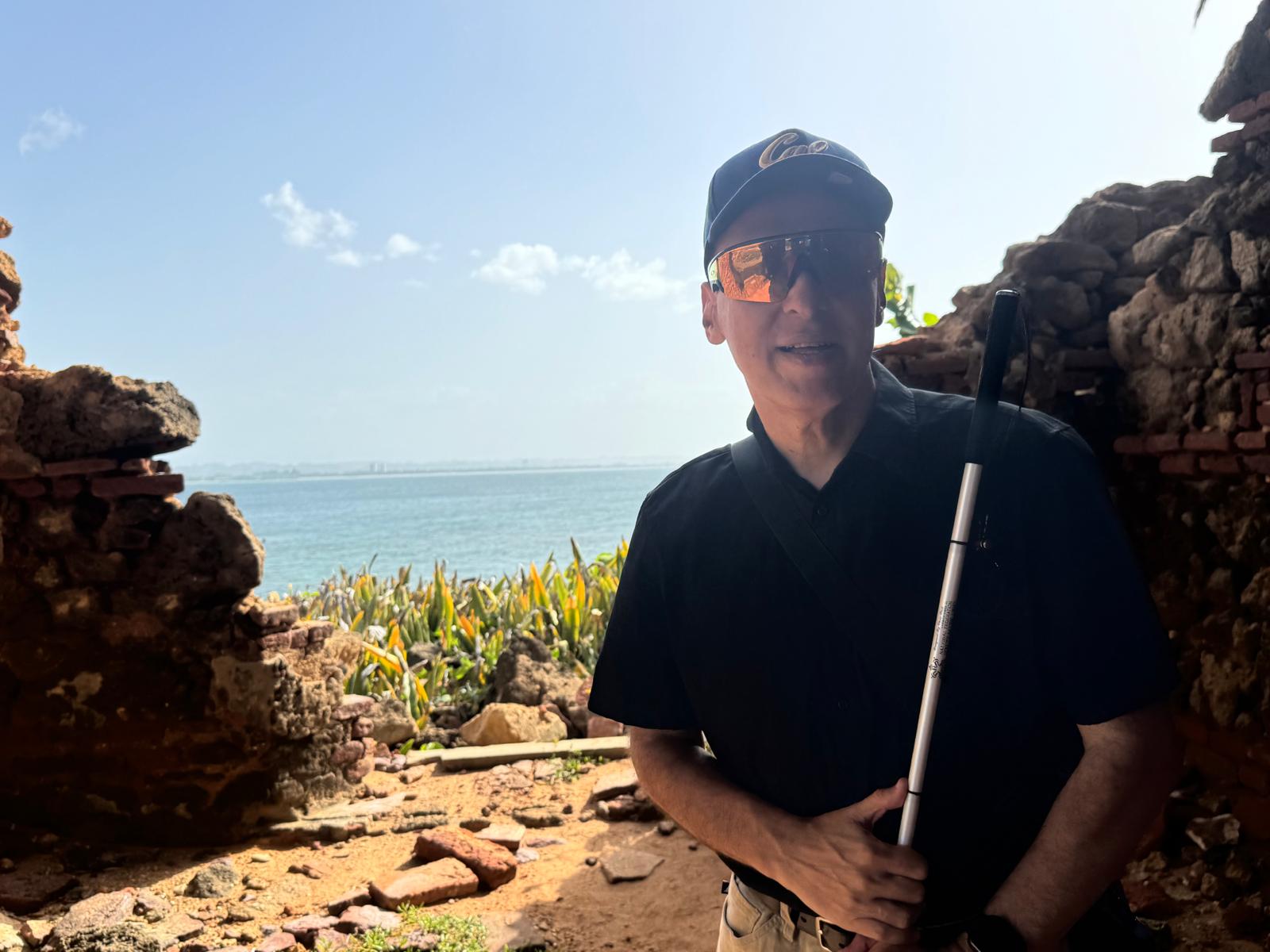 Manolo looks back at the camera on the Isla de Cabras with the ocean in the background.